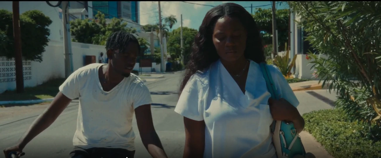 A young man on a bicycle talks to a woman walking down a sunlit Kingston street in LICK, a poetic documentary by George Malcolm Walker