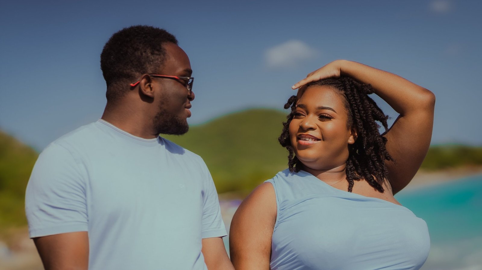 A smiling couple in pale blue on a Caribbean beach, photographed by George Malcolm Walker